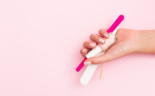 woman-holding-manicure-tools-with-copy-space